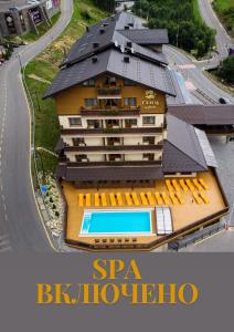 um edifício com uma piscina ao lado de uma estrada em Ganz & SPA em Bukovel