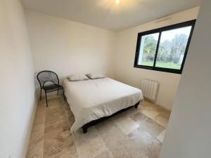 A bed or beds in a room at L'émeraude - Avec jardin