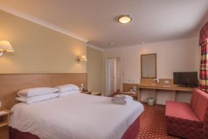 a hotel room with a bed and a chair at Crewe Arms Hotel in Crewe