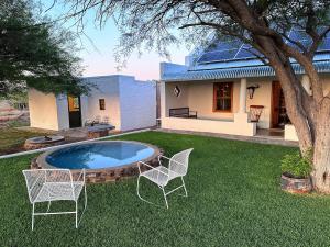 two chairs and a pool in the yard of a house at Steynskraal Gasteplaas in Beaufort West