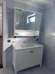STAR SUIT HOTEL في طرابزون: حمام أبيض مع حوض ومرآة
