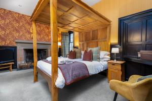 a bedroom with a canopy bed with a fireplace at Dornoch Castle Hotel in Dornoch +84 photos