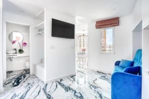 ein Wohnzimmer mit einer blauen Couch und einem Fernseher in der Unterkunft COBLANCA 5-EXCLUSIVO Loft 5-6 in Benidorm