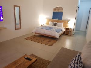 a bedroom with a bed and a mirror and a table at Villas Rocher - Villa 2 in Grand-Baie