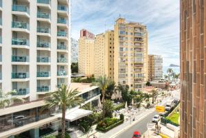 eine Stadtstraße mit hohen Gebäuden und Palmen in der Unterkunft COBLANCA 5-EXCLUSIVO Loft 5-6 in Benidorm