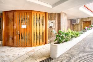 eine große Holztür in einem Gebäude mit Pflanzen in der Unterkunft COBLANCA 5-EXCLUSIVO Loft 5-6 in Benidorm + 35 Fotos