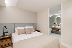1 dormitorio blanco con 1 cama grande y baño en Luxury flat Mayor V, en Madrid