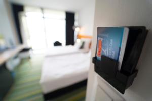 a hotel room with a bed and a tv on a wall at Fenyves Yacht Club Superior in Balatonfenyves