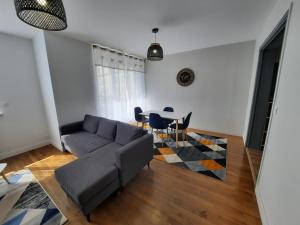 ein Wohnzimmer mit einem Sofa und einem Tisch in der Unterkunft Appartement cœur de ville in Beauvais
