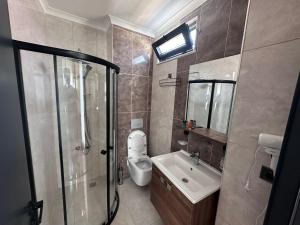 a bathroom with a shower and a toilet and a sink at STAR SUIT HOTEL in Trabzon