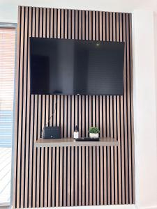 een flatscreen-tv aan een muur met een plank bij The Works - Two bed penthouse in Manchester