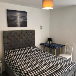 a bedroom with a bed and a table and a chair at Tolcarne Guest House in Newquay