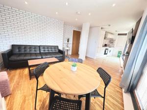 a living room with a table and chairs and a couch at The Works - Two bed penthouse in Manchester