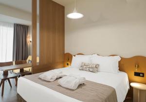a hotel room with a bed with towels on it at Alinea Market Agora Square in Limassol