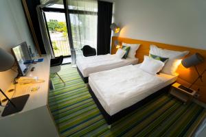Habitación de hotel con 2 camas y ventana en Fenyves Yacht Club Superior, en Balatonfenyves