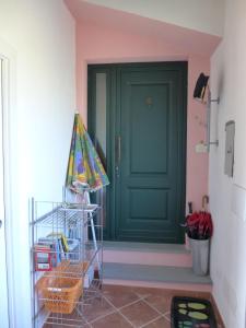 Una puerta verde en una habitación rosa con una cesta en Mini-Appartement Casa Colombana mit Panoramablick, en Aulla