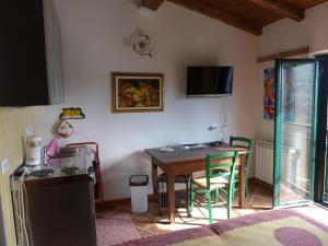 奧拉的住宿－Mini-Appartement Casa Colombana mit Panoramablick，一间用餐室,配有一张桌子和一台墙上的电视