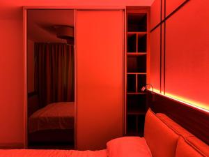 a red room with a mirror and a bed at URBAN OASIS Pallady in Bucharest
