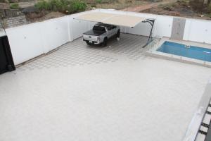 a parking lot with a truck parked next to a swimming pool at Banner Vacation Home & Swimming Pool in Prampram