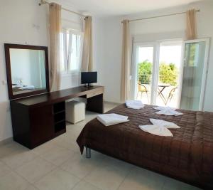 a bedroom with a bed and a desk with a mirror at Thasos Seaside Serenity - Seaview & Garden Nests in Astris