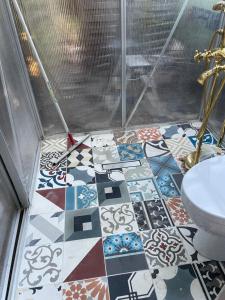 uma casa de banho com piso em azulejo e um WC. em Zimmer in Ferienhäusschen am See / Karstädt em Karstädt