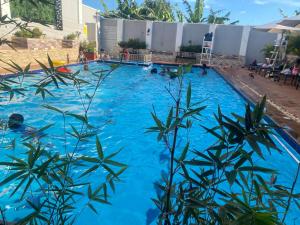 une grande piscine d'eau bleue dans l'établissement Perla Hotel, à Kampala