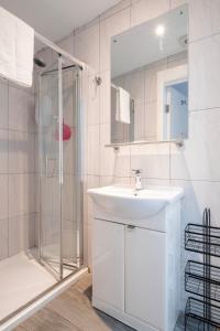 a white bathroom with a sink and a shower at Parliament Street Town House in Ennistymon