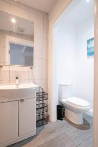 a bathroom with a white sink and a toilet at Parliament Street Town House in Ennistymon