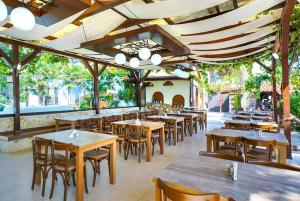 um restaurante com mesas e cadeiras de madeira e um monte delas em Thassos ESPERIA HOTEL em Pefkari
