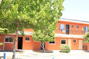 een oranje gebouw met bomen ervoor bij Motel Las Fuentes in Mexicali