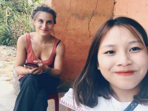 een jong meisje zit naast een vrouw bij Ly Quoc Tuan Homestay in Quản Bạ