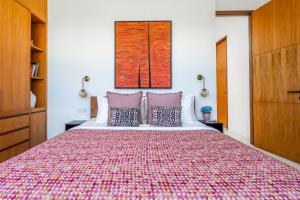 a bedroom with a large bed with a colorful bedspread at Mandala Residences in Canggu