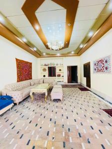 uma grande sala de estar com um sofá e mesas em Yusuf Gold House em Samarkand