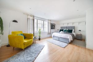 a bedroom with a bed and a yellow chair at LiveStay-Fabulous One Bed Apartments on Covent Garden in London