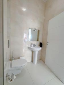 uma casa de banho branca com um lavatório e um WC em Lovely flat close to St julians with 6 beds in 3 rooms for 8 people em Is-Swieqi