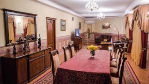 a dining room with a table and chairs and a living room at Reikartz Dostar Karaganda in Karagandy