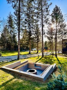 a swimming pool in the middle of a park with trees at Cabana Sia in Sibiu