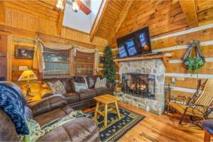 a living room with a couch and a fireplace at A Charming Cabin, Pool, Firepit, Hot Tub-jacuzzi in Gatlinburg