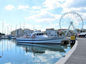 een boot is aangemeerd in een jachthaven met een reuzenrad bij Appartement Cap d'Agde, 1 pièce, 4 personnes - FR-1-249-20 in Cap d'Agde