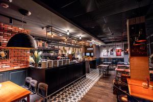 a restaurant with a bar with tables and chairs at Ibis Szczecin Centrum in Szczecin