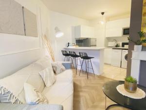 a living room with a white couch and a table at Top Location apartment 10 min Disneyland in Bussy-Saint-Georges
