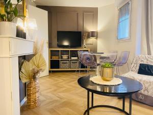 a living room with a table and a tv at Top Location apartment 10 min Disneyland in Bussy-Saint-Georges