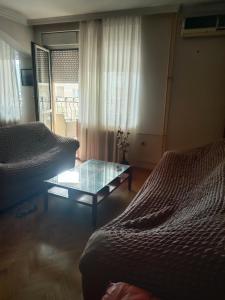 sala de estar con 2 camas y mesa de cristal en Exit 2024, en Novi Sad
