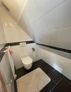 a small bathroom with a toilet and a rug at Dach Zimmer D1 in Falkenberg