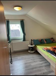a small bedroom with a bed and a window at Dach Zimmer D1 in Falkenberg