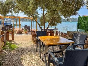 a wooden table and chairs with a view of the water at Ekin Pansiyon in Kaleucagız