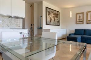 uma cozinha e uma sala de estar com uma mesa de vidro em Capo Ceraso Family Resort em Costa Corallina