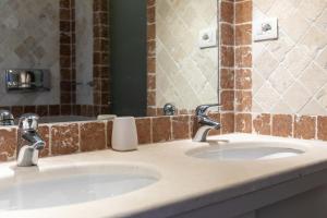 Baño con 2 lavabos y espejo en Capo Ceraso Family Resort, en Costa Corallina