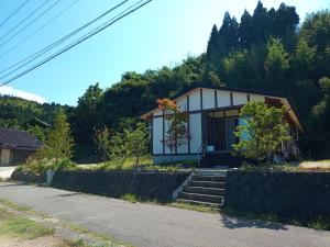 una pequeña casa al lado de una carretera en 能登島ゲストハウスうたたね, en Nanao