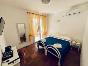 a bedroom with a blue bed and a mirror at B&B De Janas in La Caletta